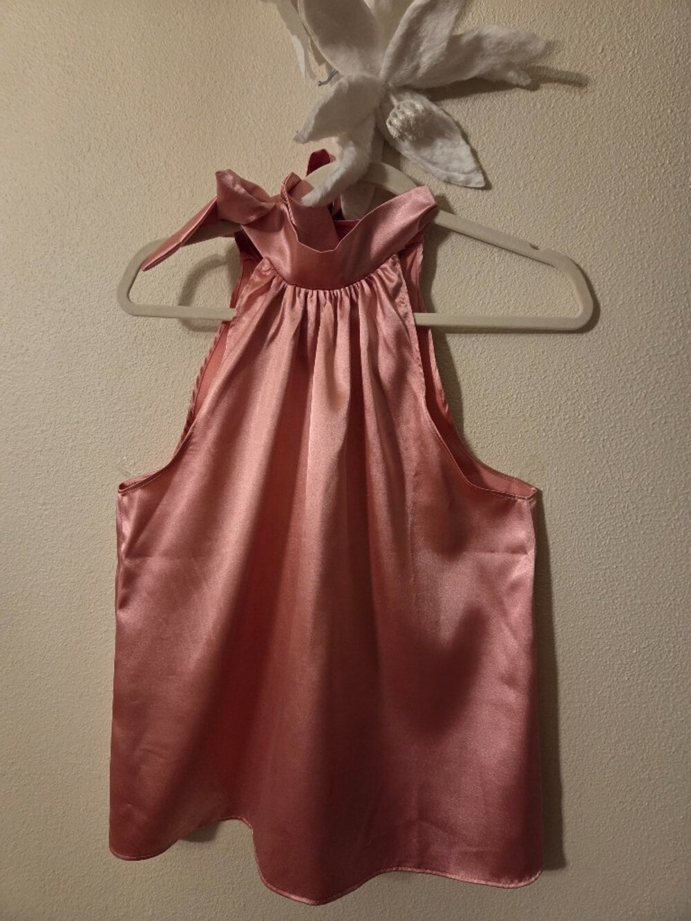 Satin halter top featuring a high gathered neckline and a decorative bow tie